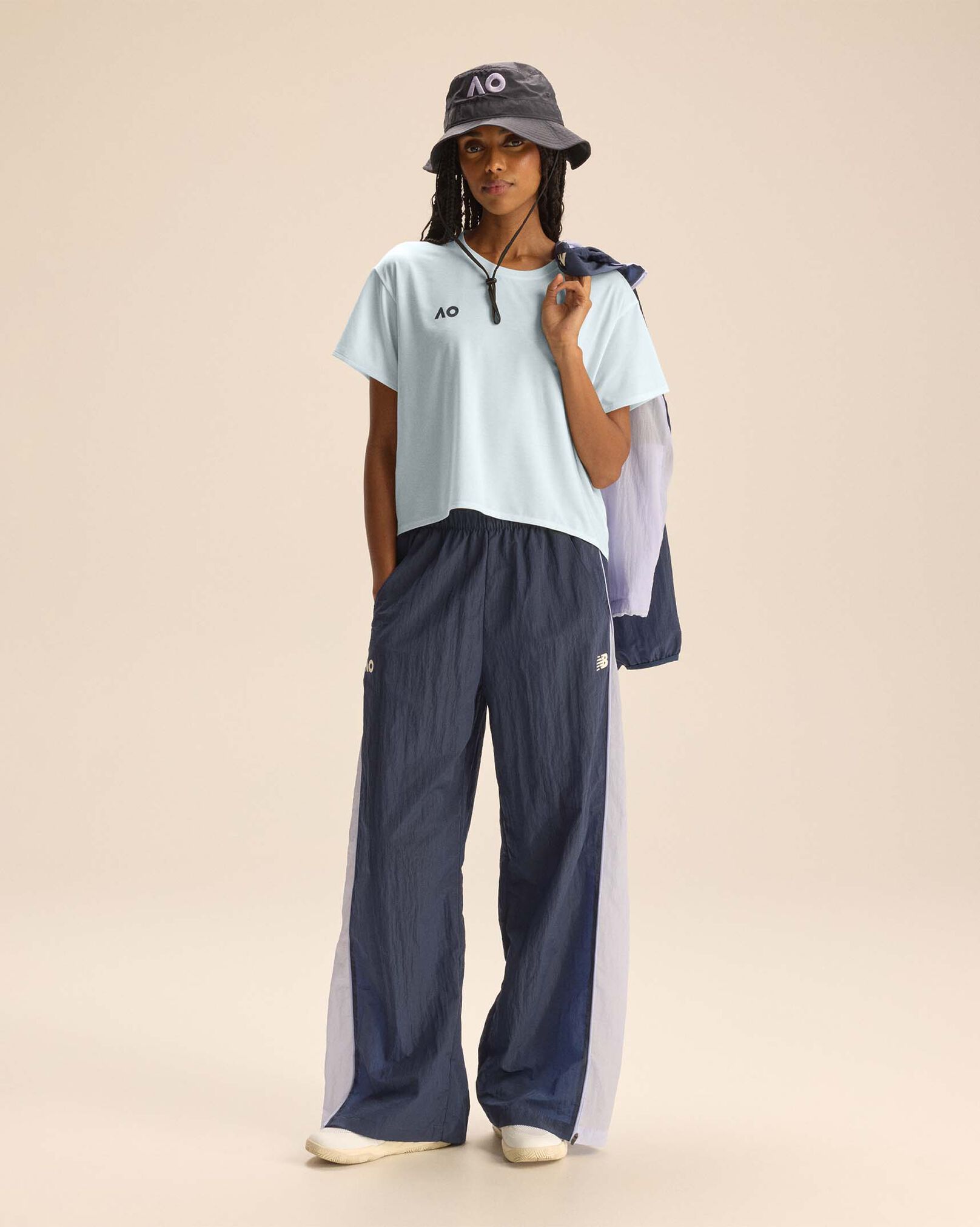 A person standing against a tan studio backdrop.