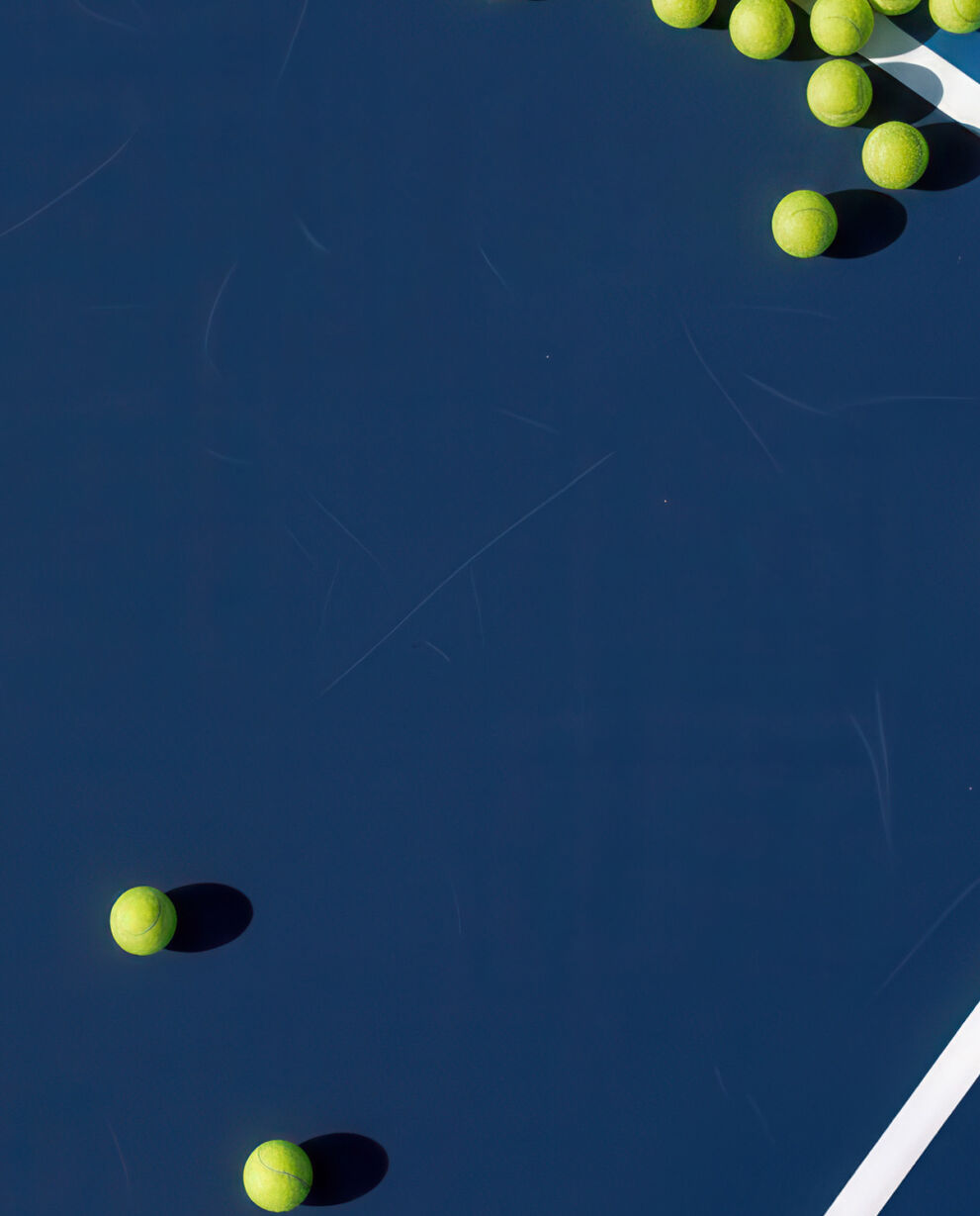 Tennis balls laying on a tennis court.