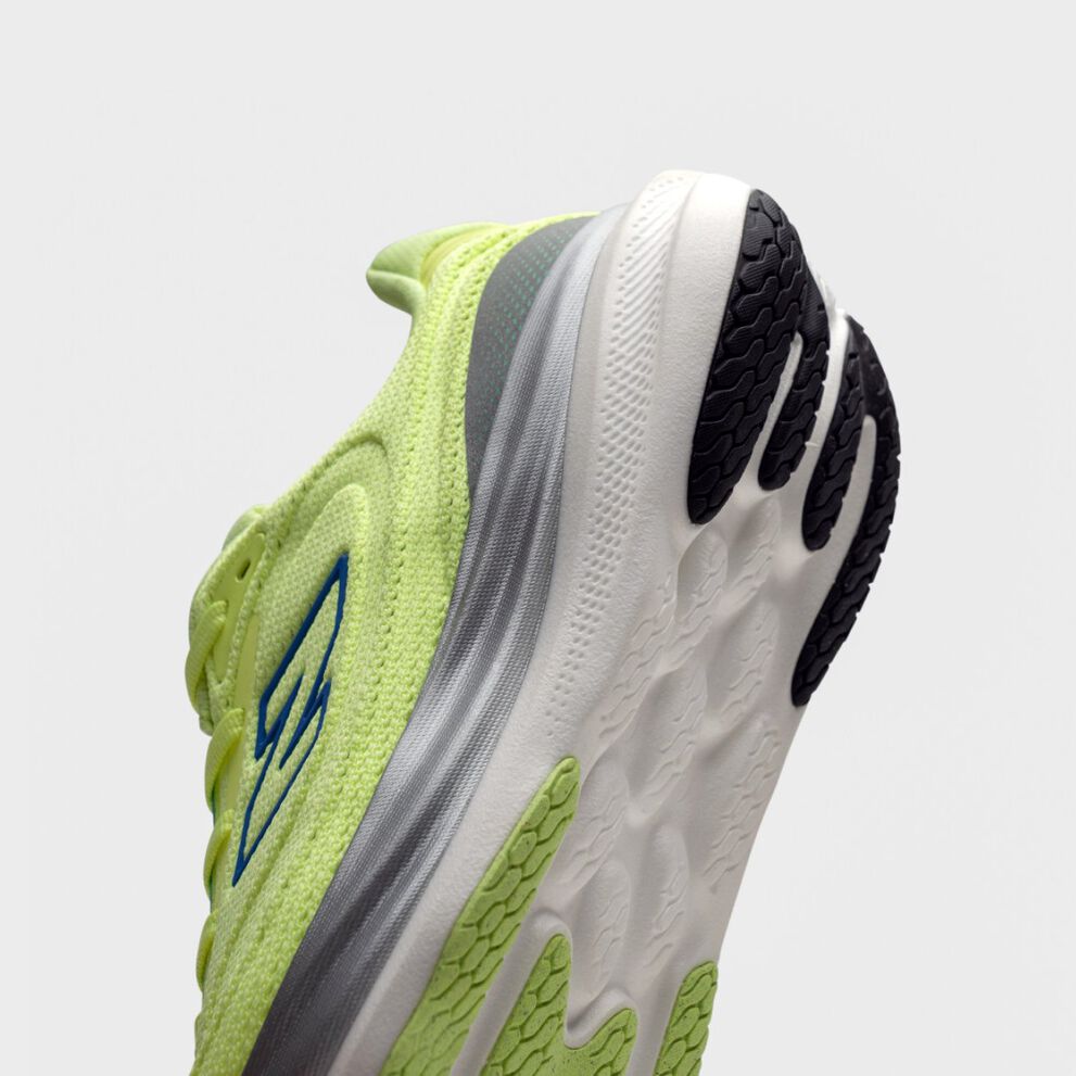 Close-up of the heel and sole of a bright yellow-green New Balance running shoe with blue logo, gray accents, and white sole featuring black tread. 